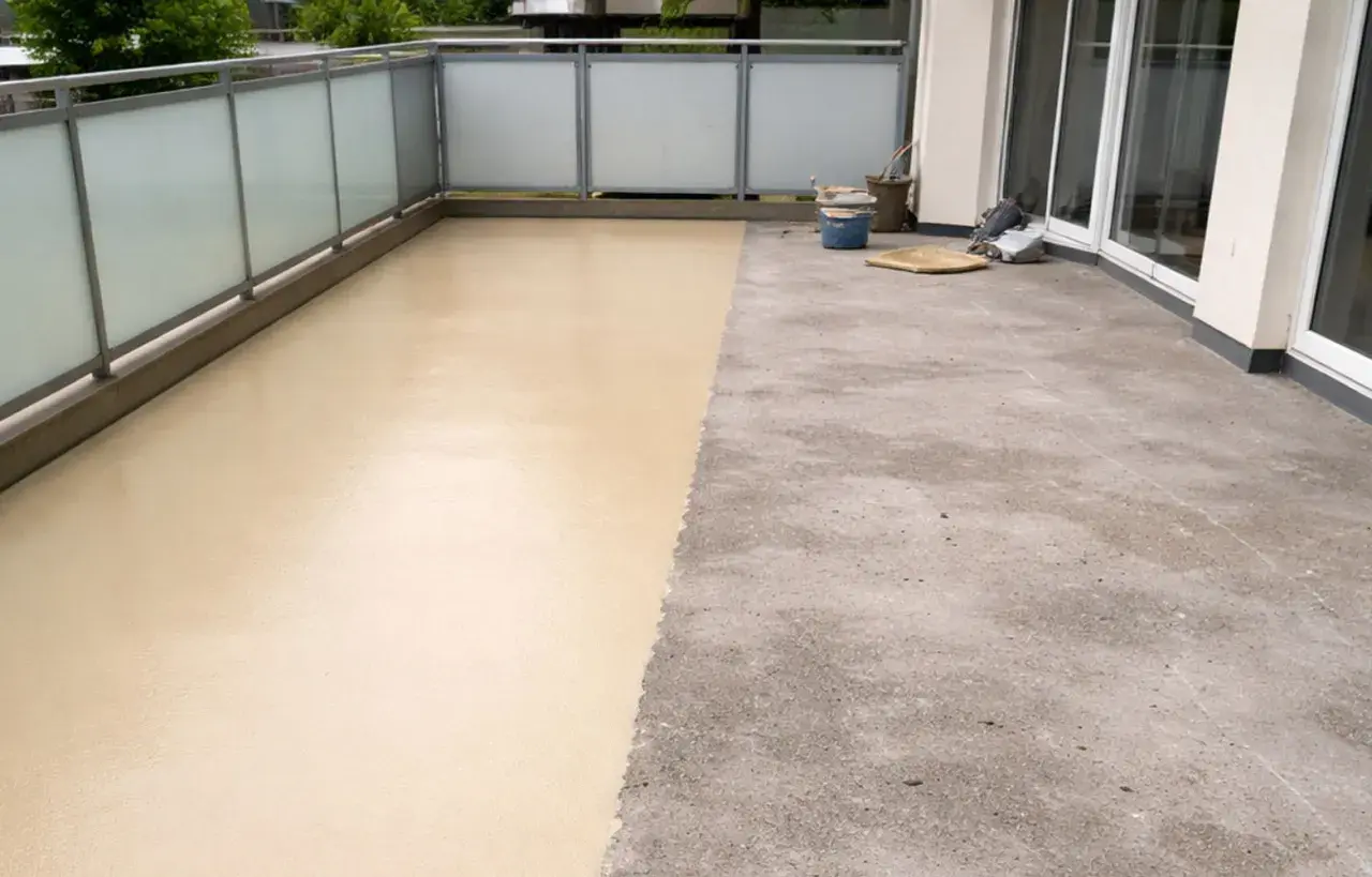 Balcone con pavimenti in resina per esterni: metà grezzo, metà beige applicato. Valutare pro e contro per una scelta informata.