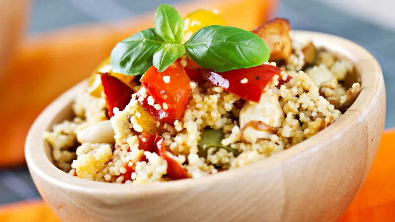 Ciotola di couscous con verdure colorate e basilico, perfetta per le ricette svezzamento 6 mesi.