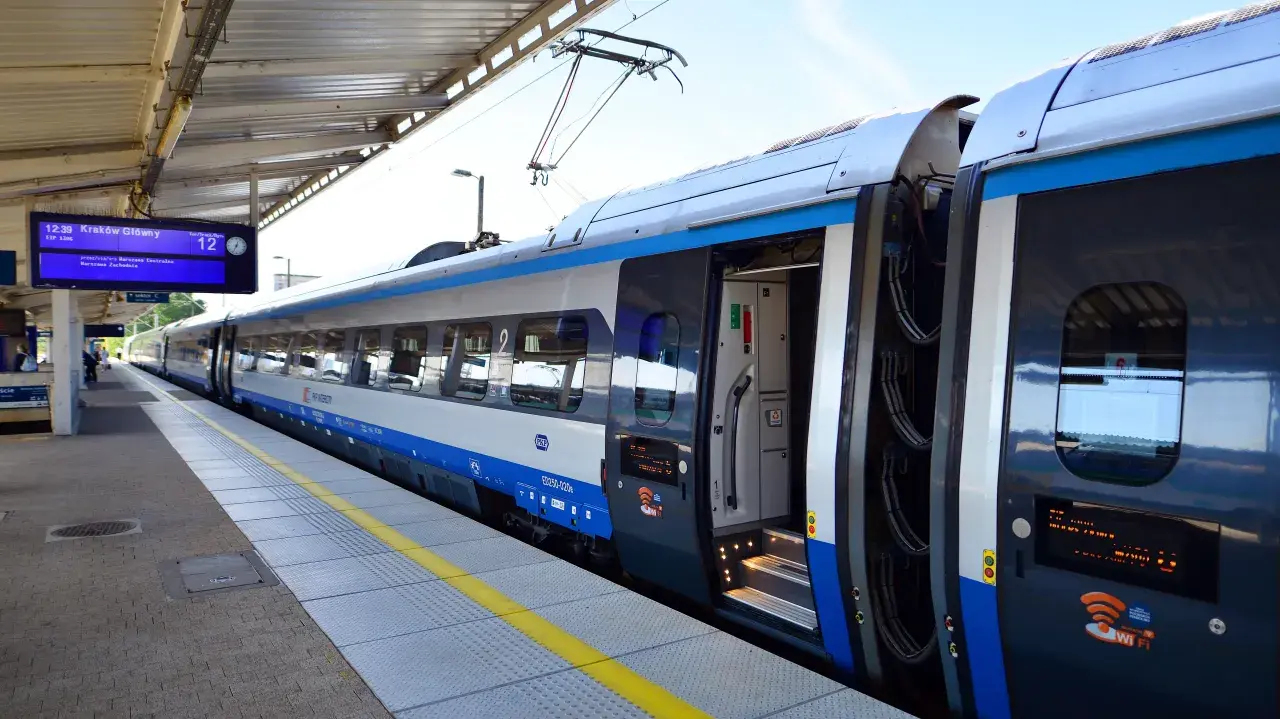 Pociąg PKP Intercity na peronie, tablica informacyjna pokazuje odjazd do Krakowa. Czekam na pociąg, mam nadzieję, że nie będzie awarii PKP.