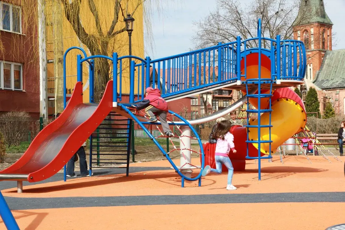 Kolorowy plac zabaw w Ełku oferuje mnóstwo atrakcji dla dzieci: zjeżdżalnie, ścianki wspinaczkowe i tunele. Radość maluchów gwarantowana!