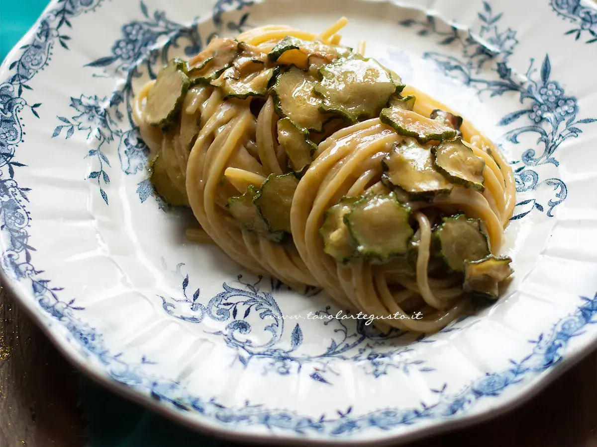Spaghetti alla Nerano, un piatto cremoso con zucchine fresche su un piatto decorato.