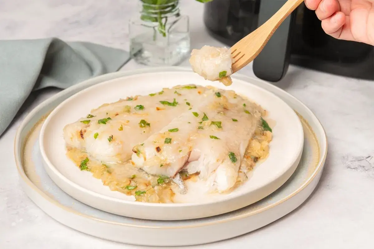 Deliciosa merluza en salsa, recién hecha en airfryer. Un bocado perfecto con perejil fresco.