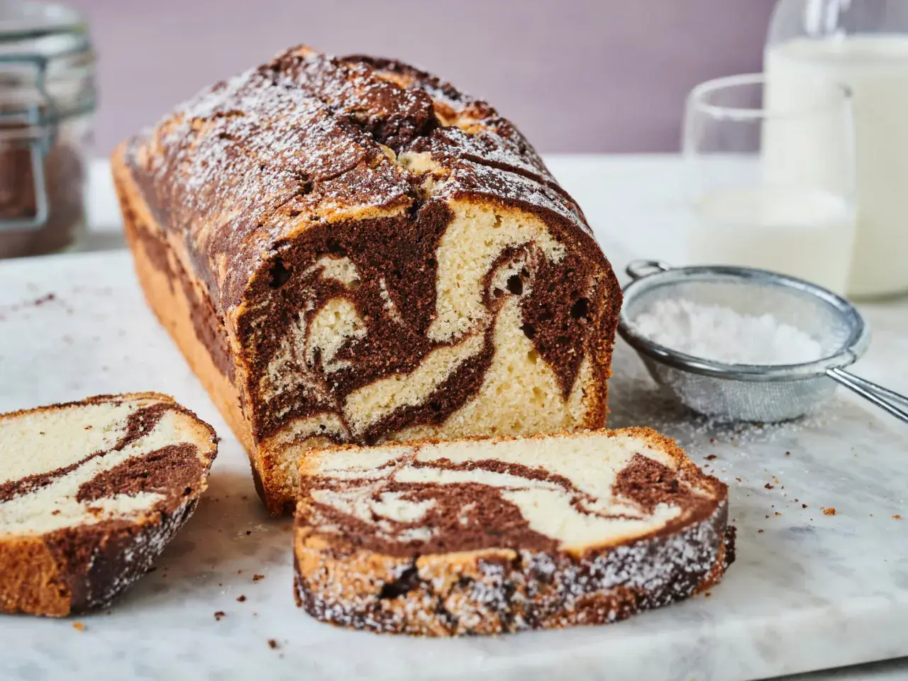 Ein köstlicher Marmorkuchen, frisch gebacken und mit Puderzucker bestäubt. Dieses Marmorkuchen Rezept ist ein Klassiker.