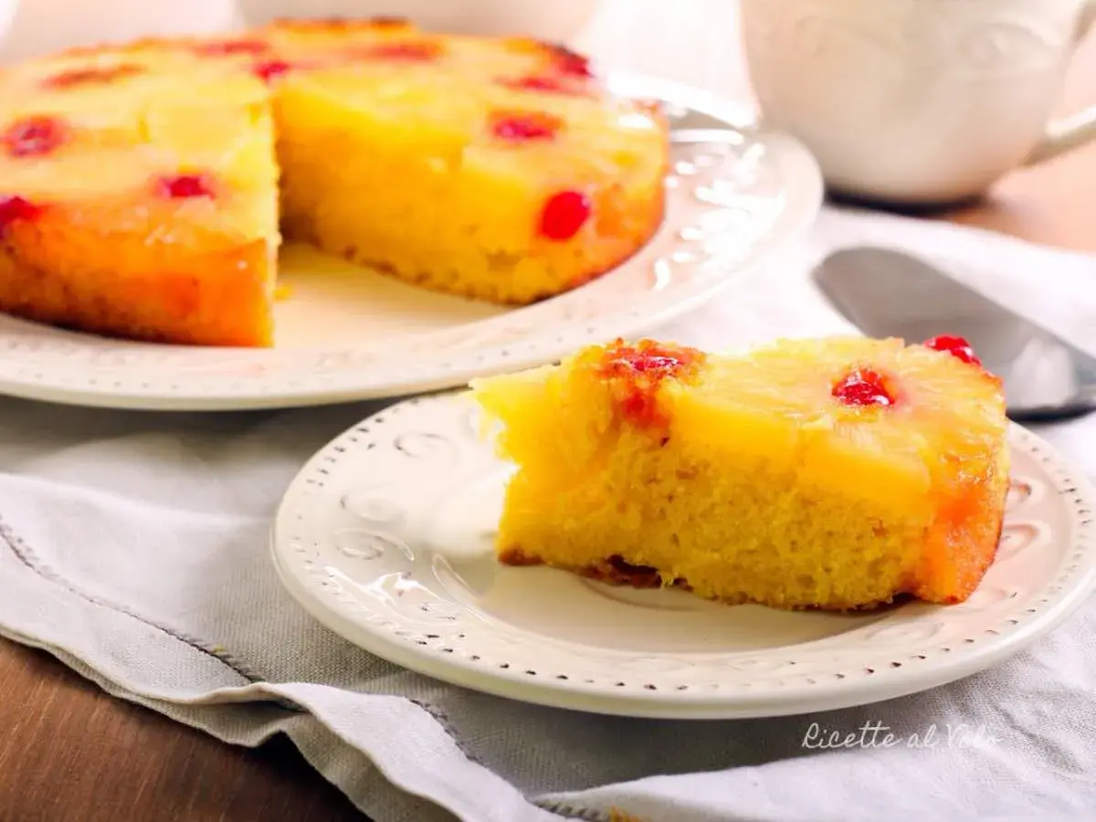 Una fetta di torta ananas, con la sua base dorata e la copertura di frutta caramellata, pronta per essere gustata.
