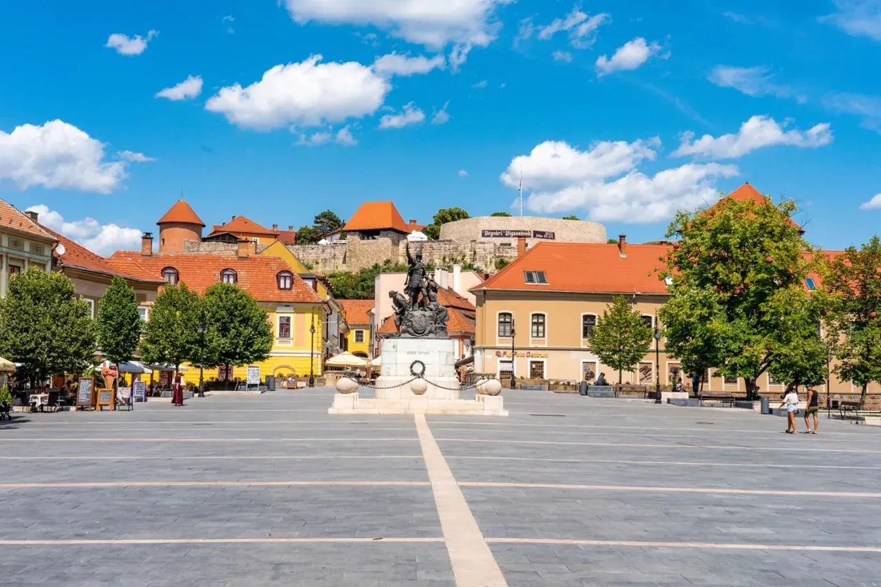 Rynek w Egerze z pomnikiem i zamkiem w tle. Wspaniałe atrakcje turystyczne i piękne widoki.