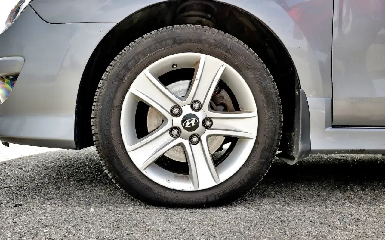 Koło samochodu z widocznym niskim ciśnieniem w oponach. Felga aluminiowa z logo Hyundai.