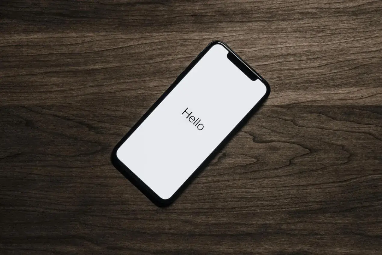 Telefon z napisem "Hello" na białym ekranie. Idealny moment, by pomyśleć, jak zaprosić dziewczynę na randkę.