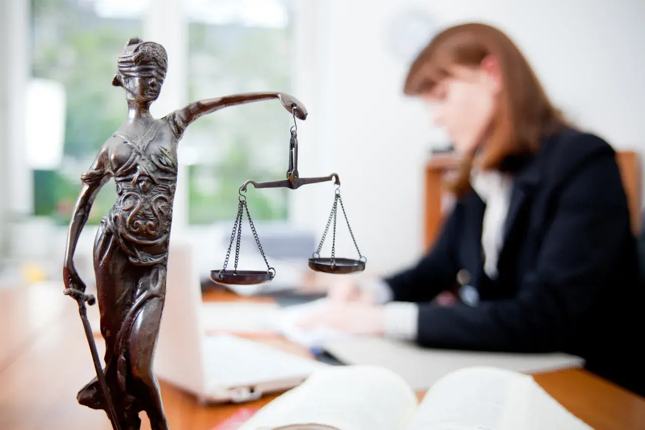 Statua della Giustizia con bilancia, avvocato al lavoro. Un successo per il ricorso invalidità civile vinto.
