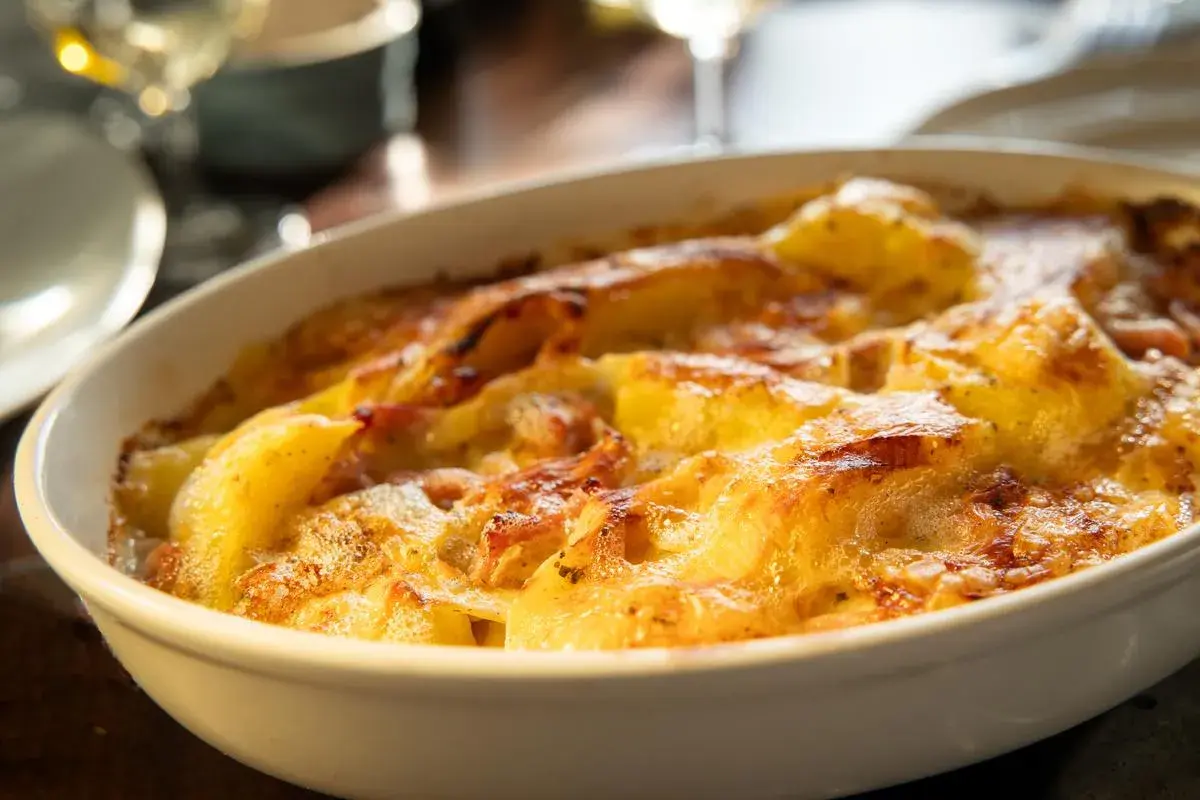 Un délicieux gratin dauphinois aux pommes de terre et reblochon, doré et gratiné, prêt à être dégusté.