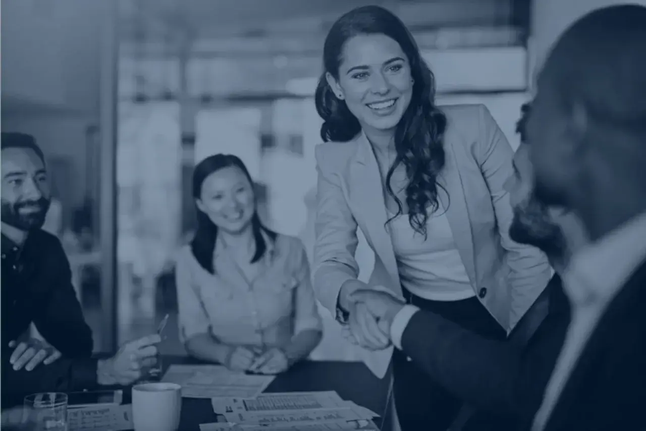 Un team sorridente, con una stretta di mano che simboleggia la collaborazione. La lista dipendenti azienda è in buone mani.
