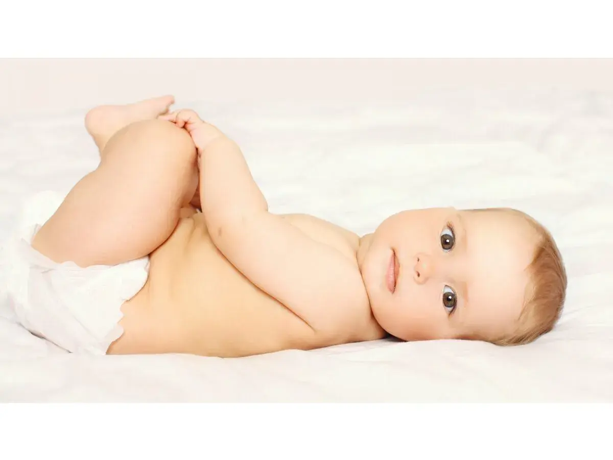 Bambino con pannolino, gambe sollevate, pronto per un cambio per prevenire la candida da pannolino.