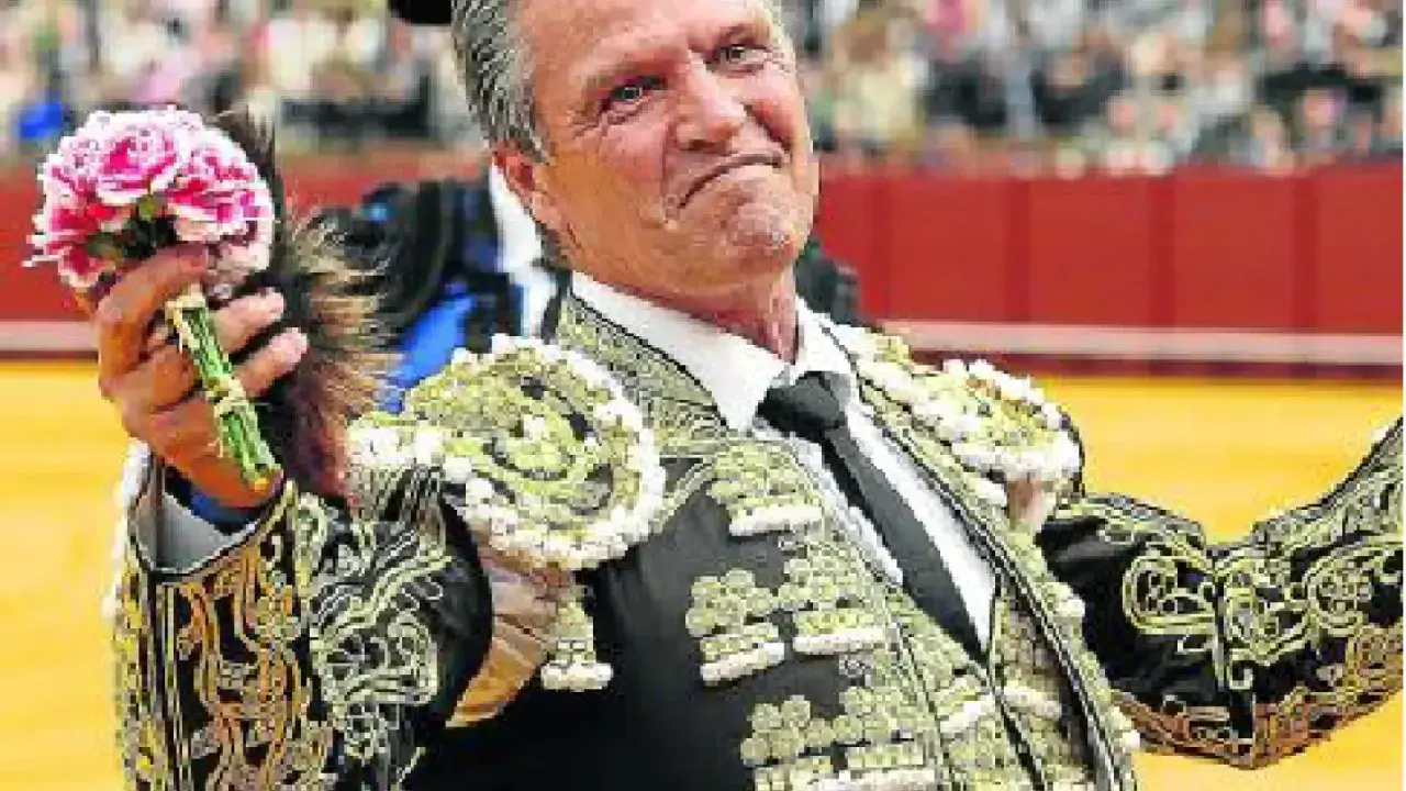 Juan Antonio Ruiz Espartaco, torero con traje de luces, ofrece un ramo de flores al público.