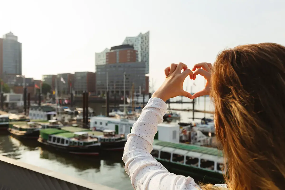 Herzförmige Geste vor Hamburgs Hafen. Ein toller Reisetipp Deutschland für alle, die maritime Städte lieben.