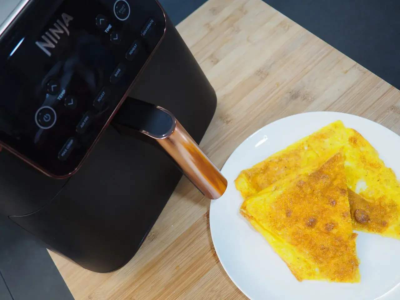 Frittata dorata appena sfornata dalla friggitrice ad aria Ninja, pronta per essere gustata.