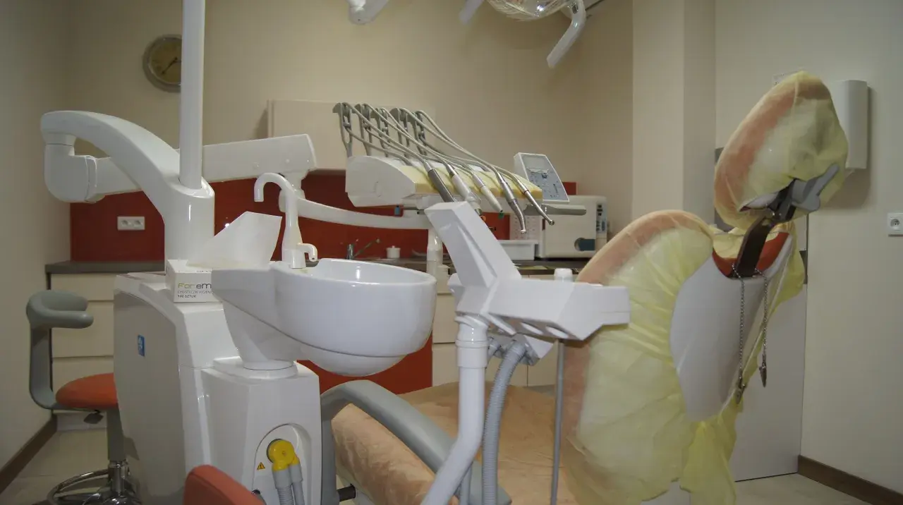 Nowoczesny gabinet stomatologiczny z fotelem dentystycznym i narzędziami.