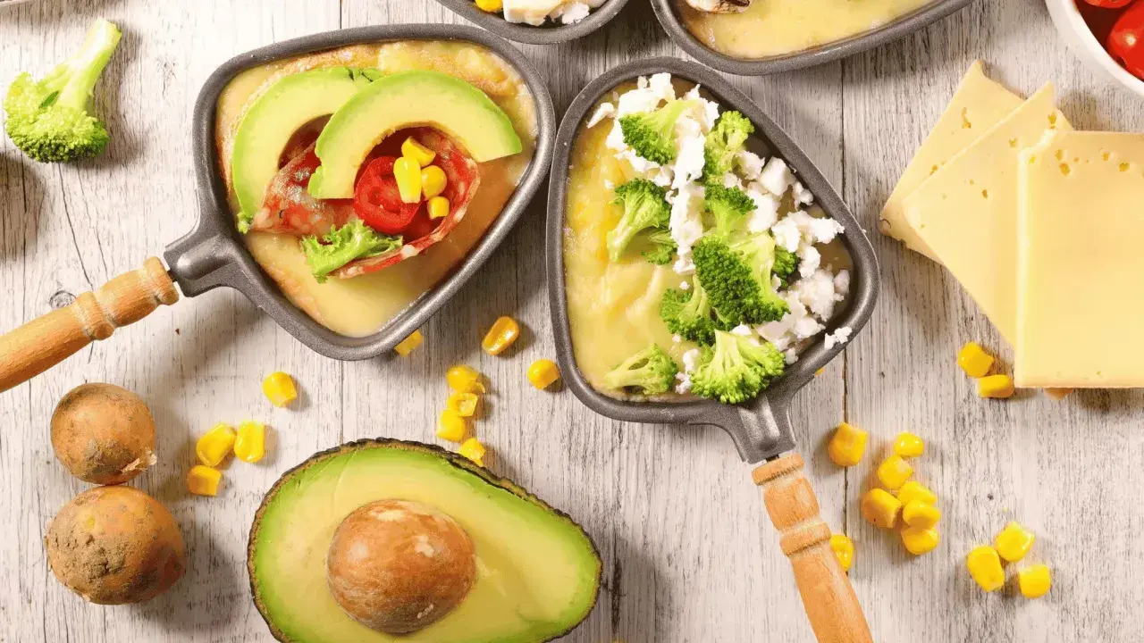 Poêlons de raclette végétarienne avec avocat, brocolis et maïs. Une option gourmande et colorée pour un repas convivial.