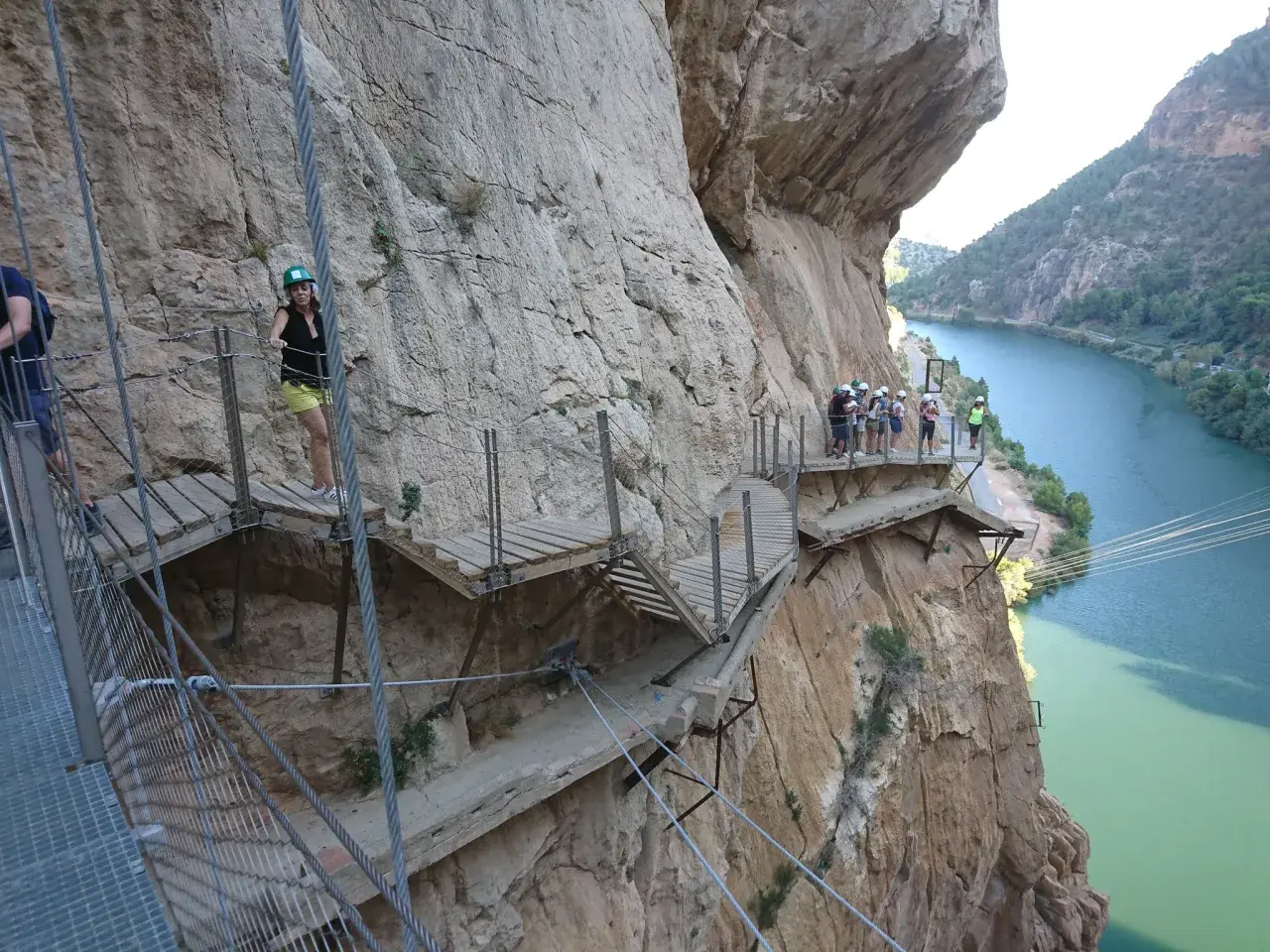 Wagemutige genießen das Malaga Wandern auf dem Caminito del Rey, einem Pfad an steilen Felswänden über einem Fluss.