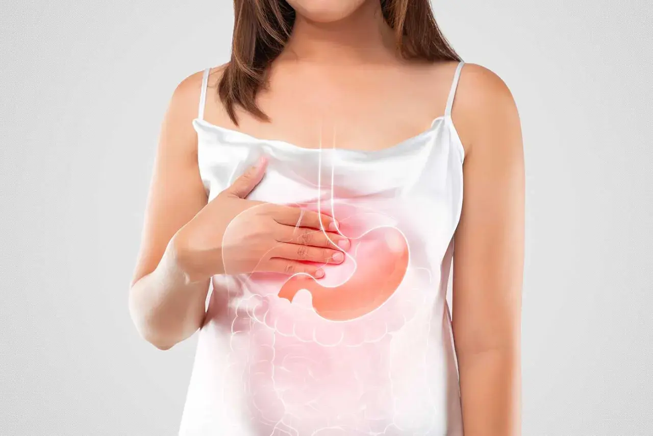 Donna con mano sullo stomaco, evidenziato da un'illustrazione luminosa. Simboleggia il bruciore di stomaco in gravidanza.