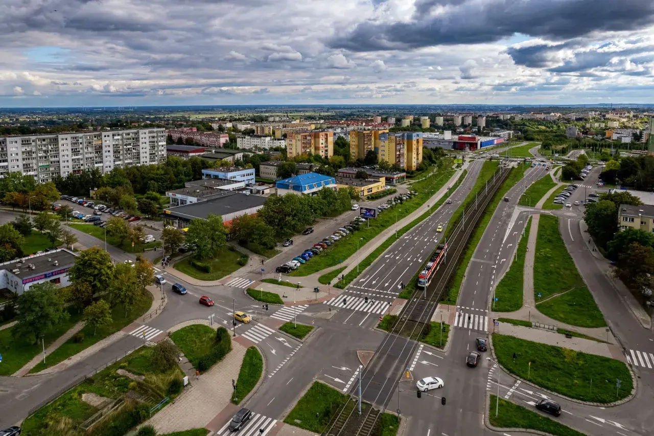 Widok z lotu ptaka na ruchliwe skrzyżowanie w Gdańsku Chełmie, z tramwajem i samochodami.