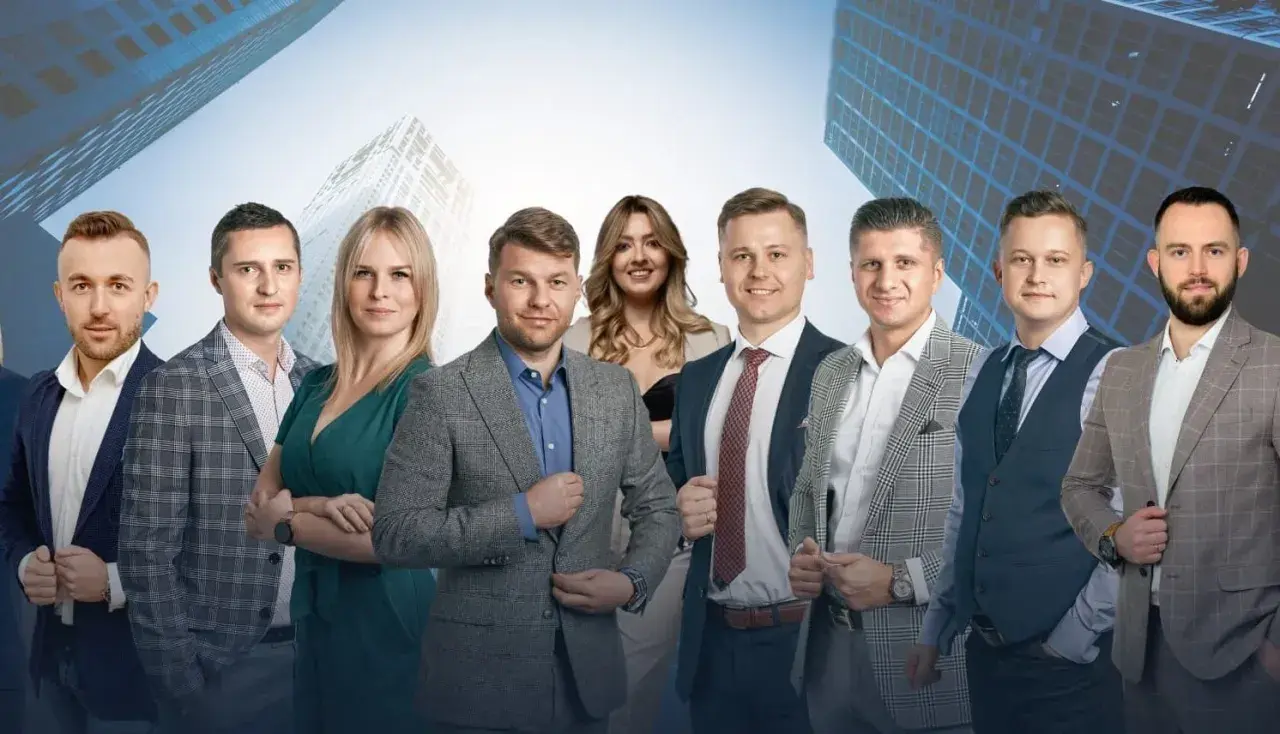 Grupa profesjonalistów w garniturach na tle nowoczesnych budynków.