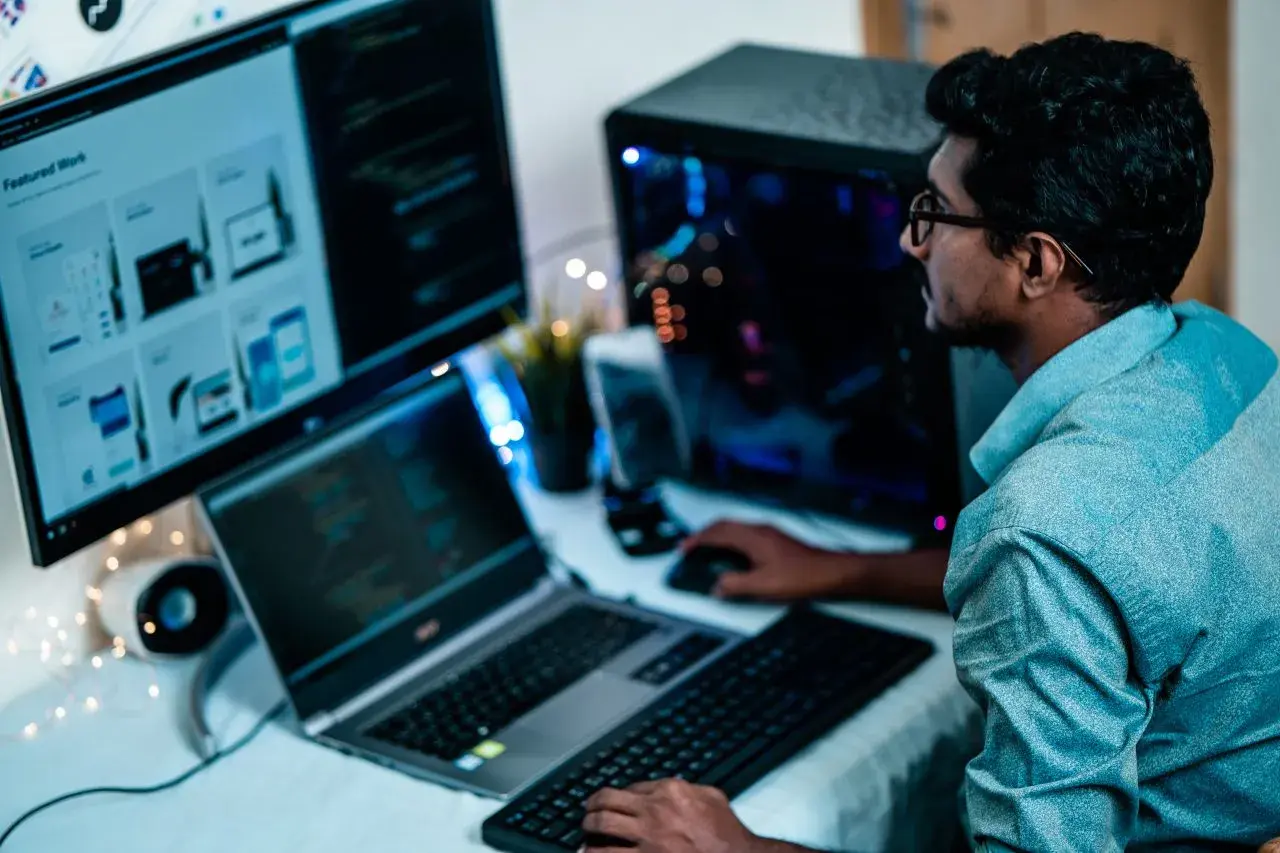 Un homme concentré sur ses écrans, le bon distance ecran yeux pour coder.