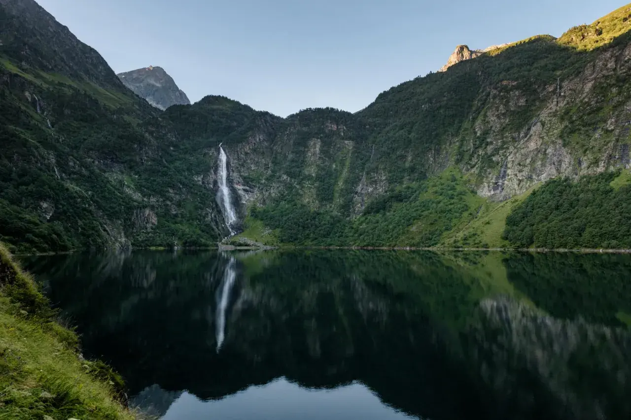Le lac d'Oo, miroir des montagnes verdoyantes et de sa cascade majestueuse, offre un spectacle paisible.