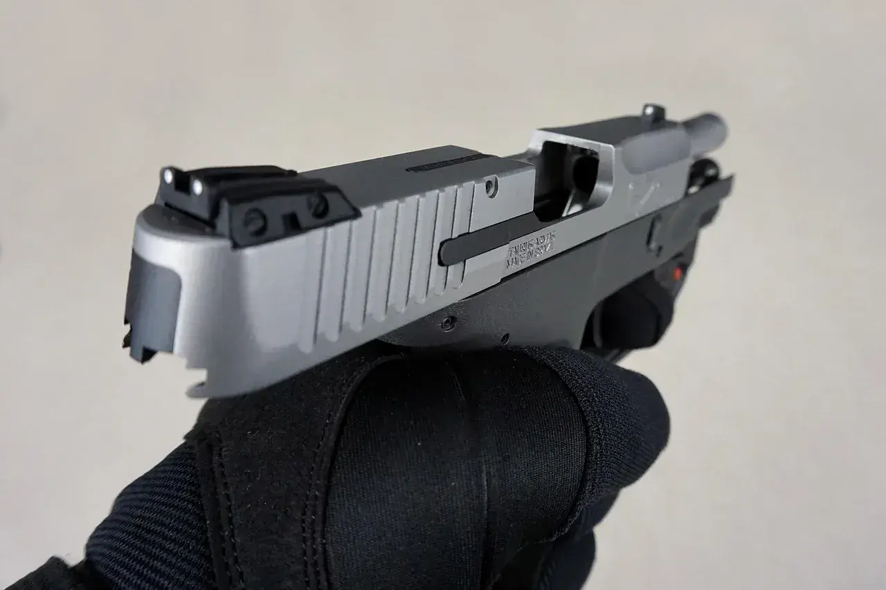 Dłoń w czarnej rękawicy trzyma pistolet. To nie jest najdroższy pistolet na świecie, ale jego precyzja i jakość wykonania budzą podziw.