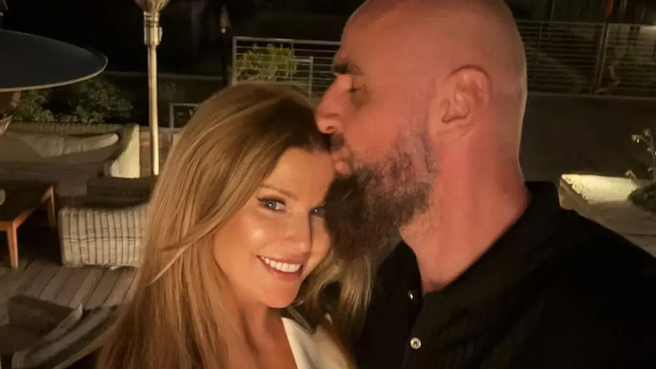 Marcin Gortat całuje swoją żonę w czoło. Para cieszy się wieczorem na tarasie.