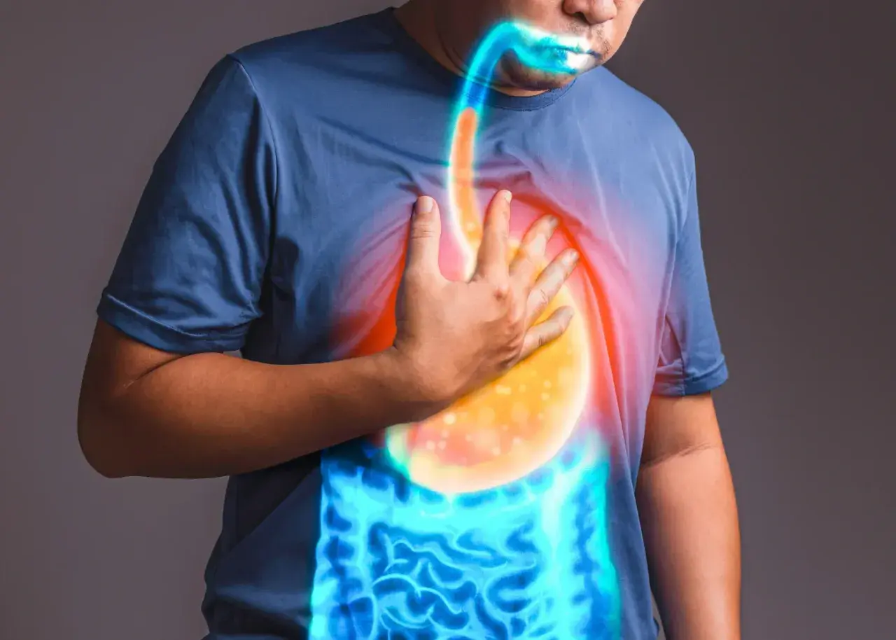Uomo con mano sul petto, evidenziando il reflusso gastroesofageo e i sintomi legati all'ansia.