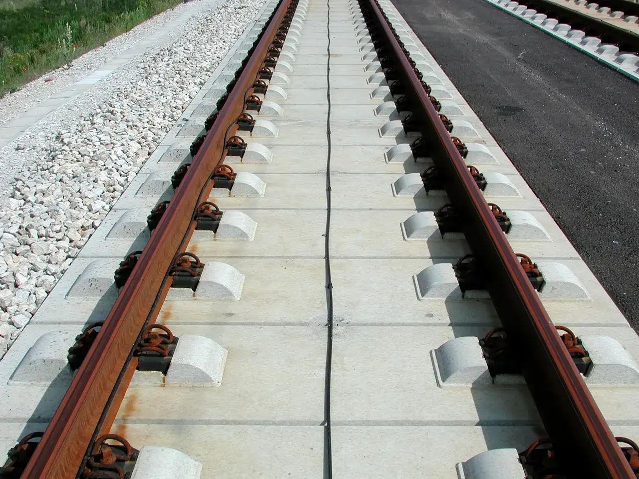 Nowe podkłady betonowe pod torami kolejowymi, gotowe na przyjęcie pociągów.