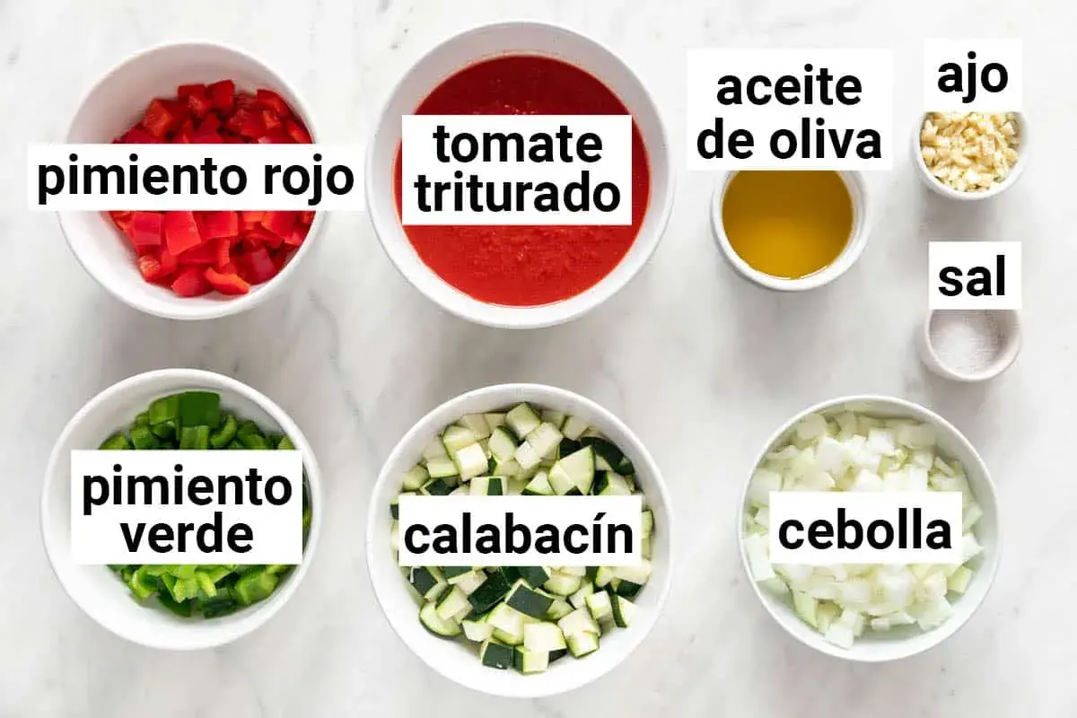 Ingredientes para hacer pisto: pimiento rojo, pimiento verde, calabacín, tomate triturado, cebolla, ajo, aceite de oliva y sal.