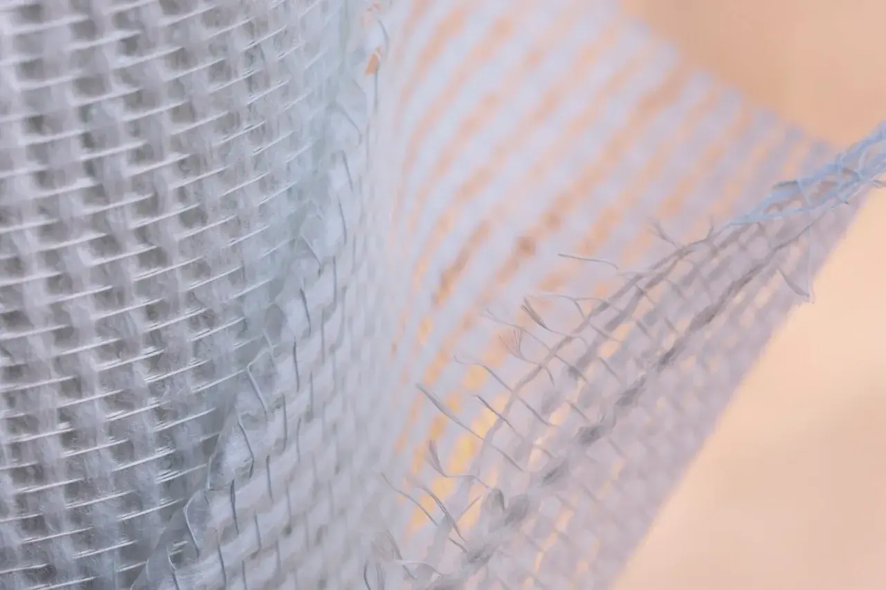 Trama di **rete fibra di vetro rinforzo strutturale**, con fili intrecciati che creano una texture robusta e flessibile, ideale per consolidamenti.