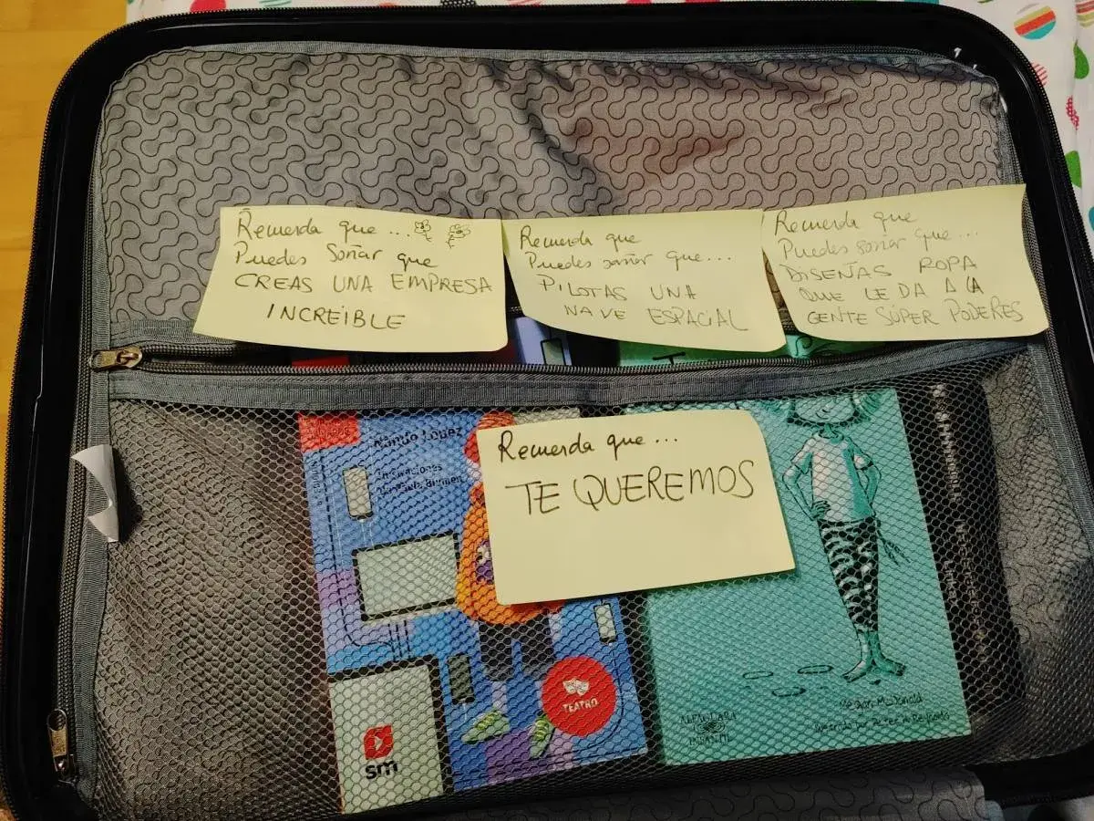 Maletas abiertas con notas que animan a soñar: crear empresas, pilotar naves espaciales, diseñar ropa con superpoderes.