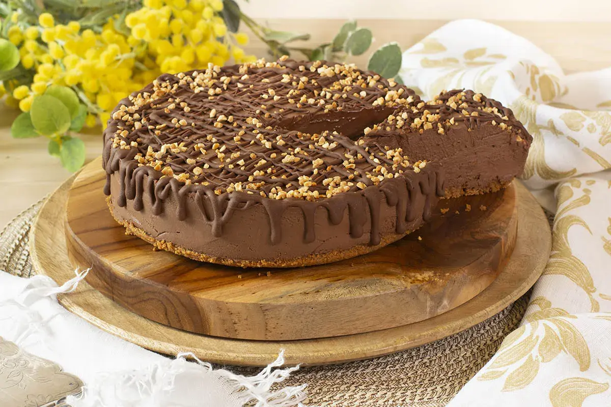 Tarta de chocolate y queso mascarpone sin horno, cubierta con frutos secos y un glaseado de chocolate. ¡Una delicia cremosa!