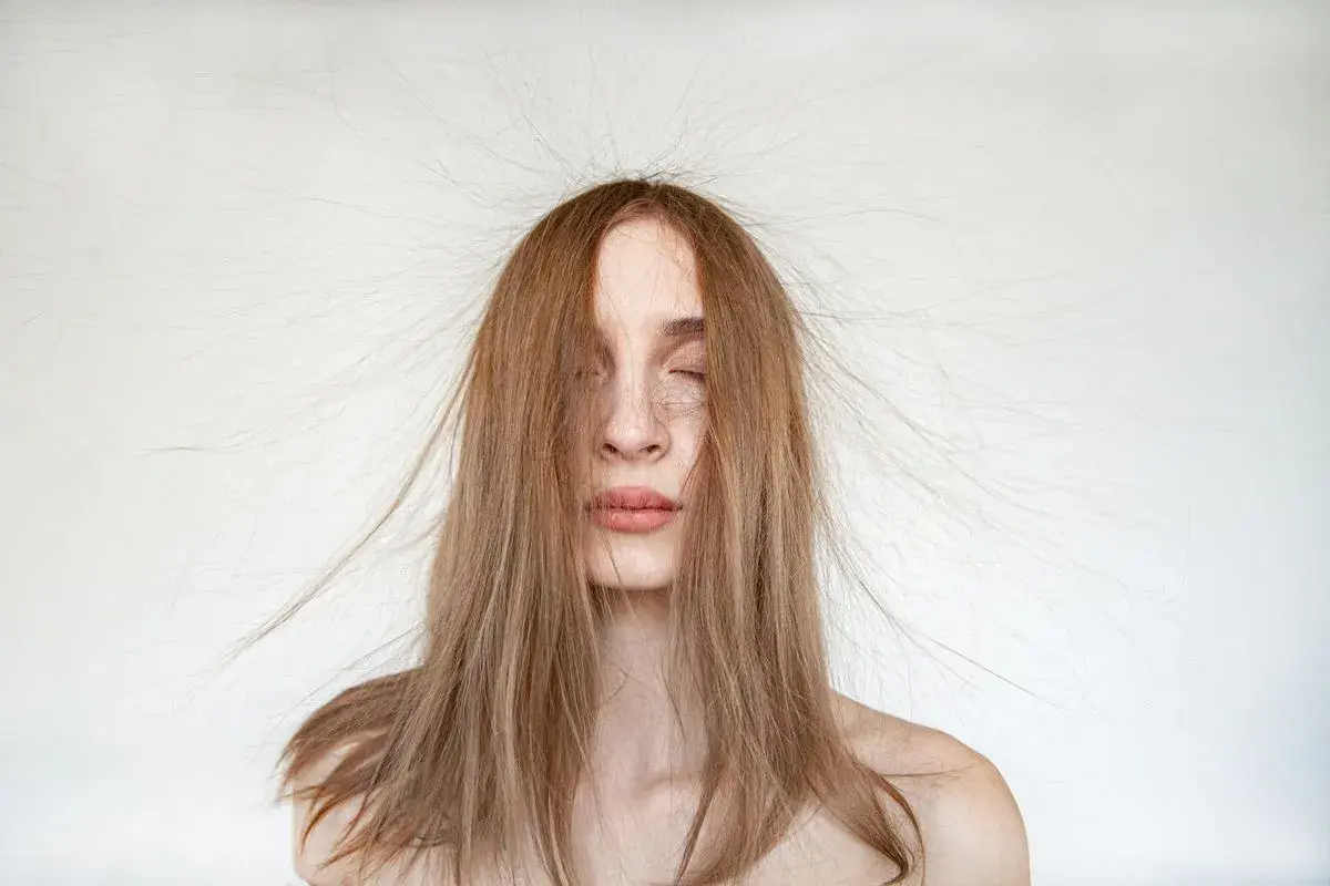 Frau mit langen Haaren, die elektrisch aufgeladen abstehen.
