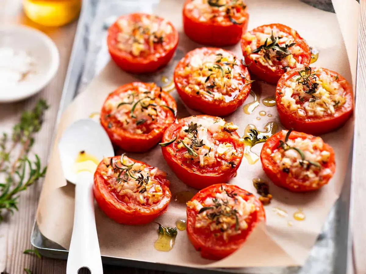 Tomates provençales garnies d'herbes et de fromage, rôties sur une plaque. Un délice parfumé !