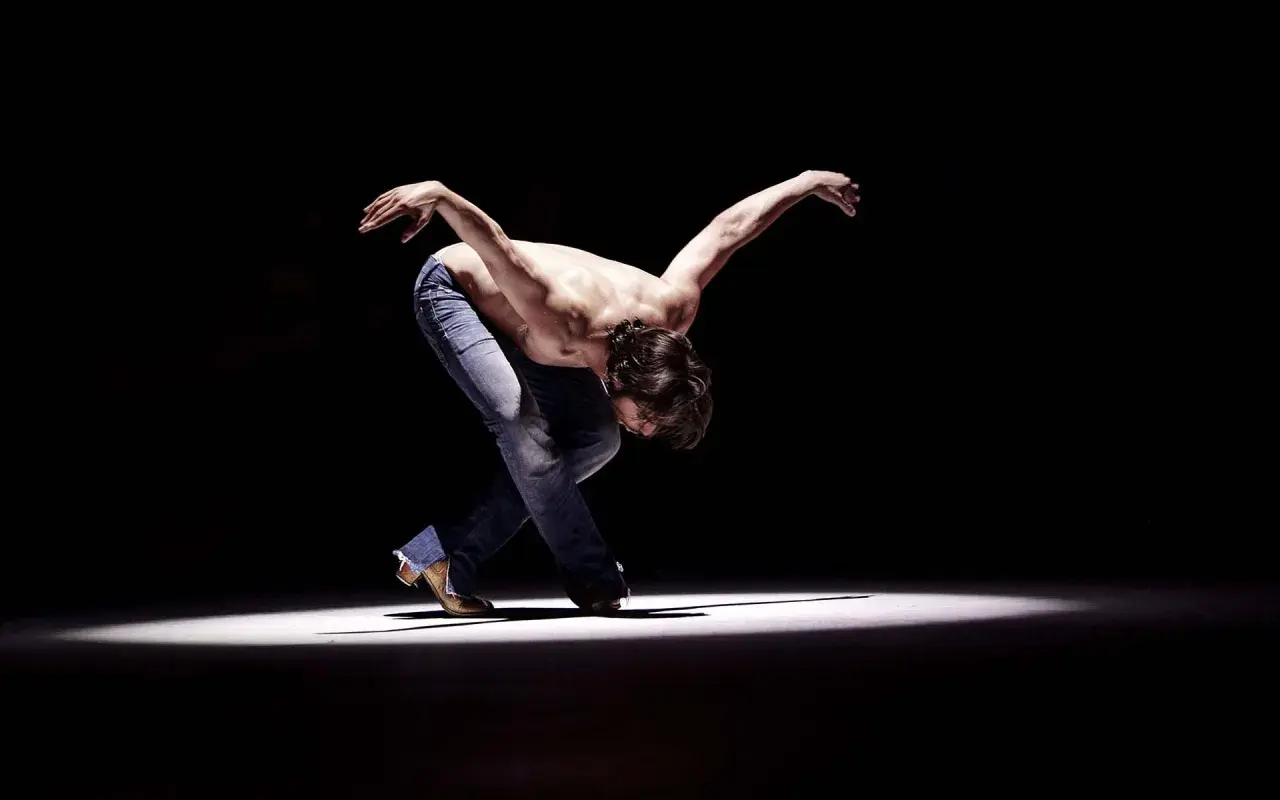 Joaquín Cortés flamenco, un torbellino de pasión y arte, se mueve con fuerza en el escenario.