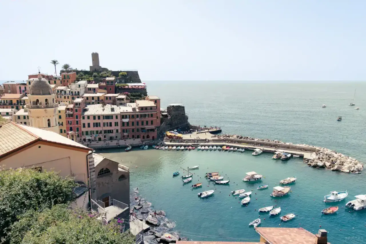 Bunte Häuser am Hafen von Cinque Terre, Italien, mit vielen Booten im türkisfarbenen Wasser.