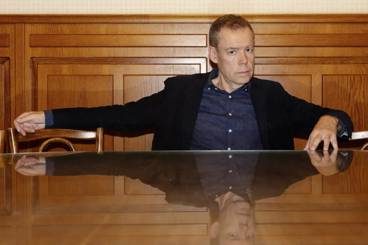 Tony Samuelsson sitter vid ett träbord med en spegelblank yta.