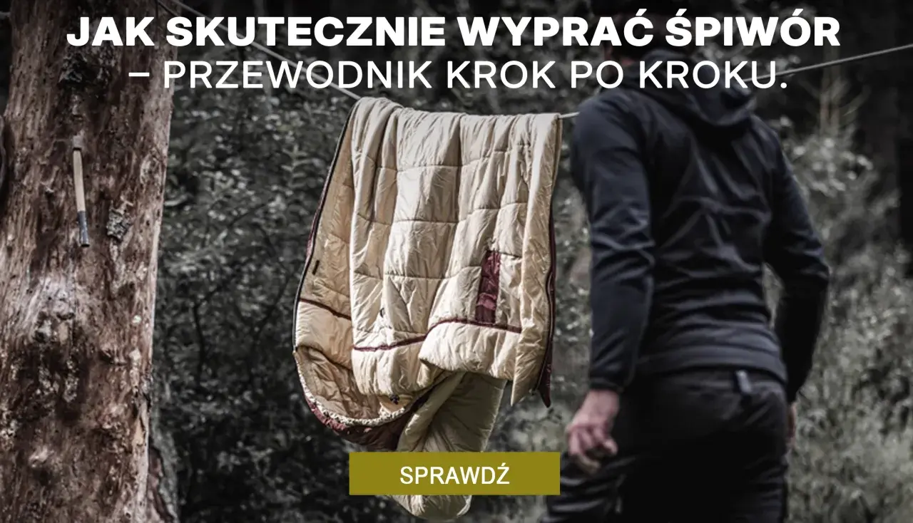 Jak prać śpiwór? Przewodnik krok po kroku. Śpiwór wisi na sznurku, obok stoi osoba w czarnej bluzie.