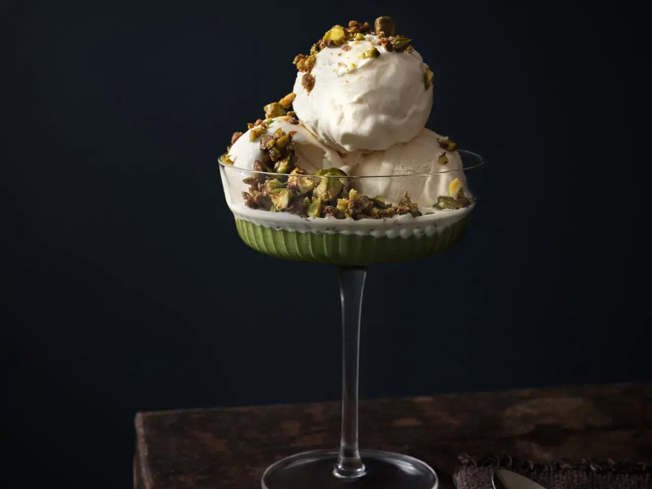 Krämig pistageglass i ett elegant glas, toppad med krossade pistagenötter. Ett perfekt pistageglass recept för en lyxig dessert.