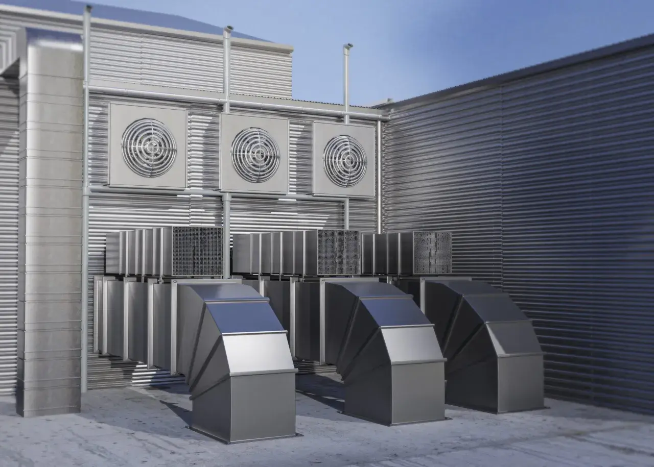 Unidades exteriores de un sistema VRV, con conductos metálicos y ventiladores en una pared acanalada.