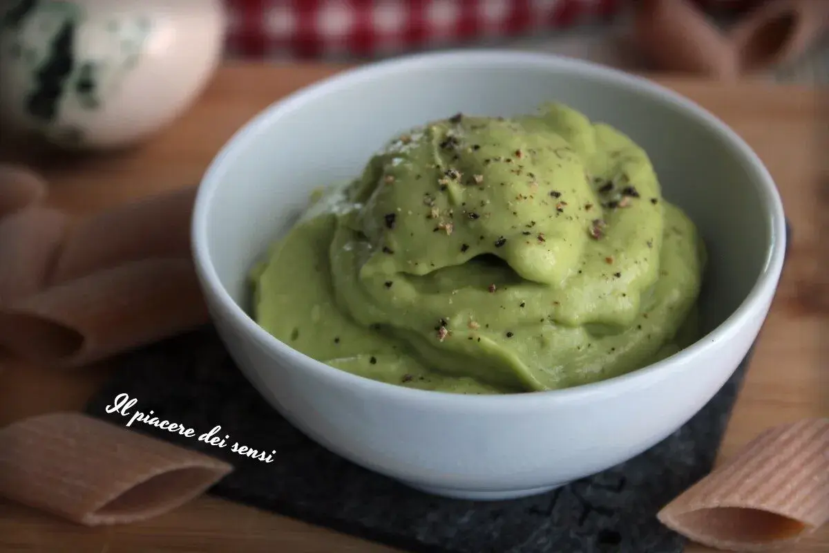 Una cremosa salsa avocado, cosparsa di pepe nero, in una ciotola bianca. Perfetta per accompagnare pasta o come dip.