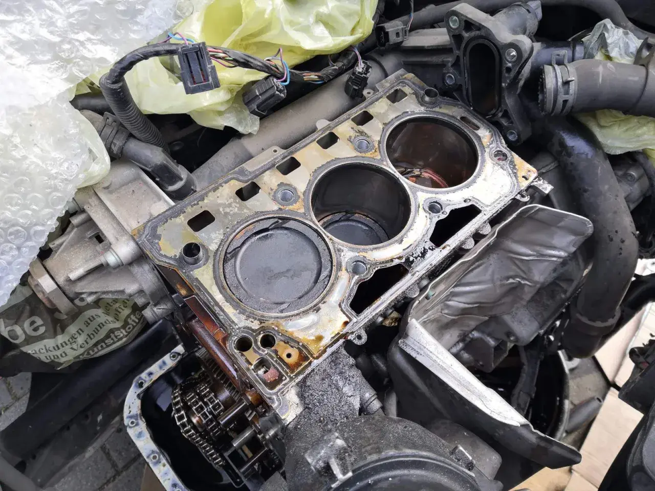 Volkswagen Motor mit defekter Zylinderkopfdichtung, wahrscheinlich DTC P0301. Öl und Schmutz sind sichtbar.