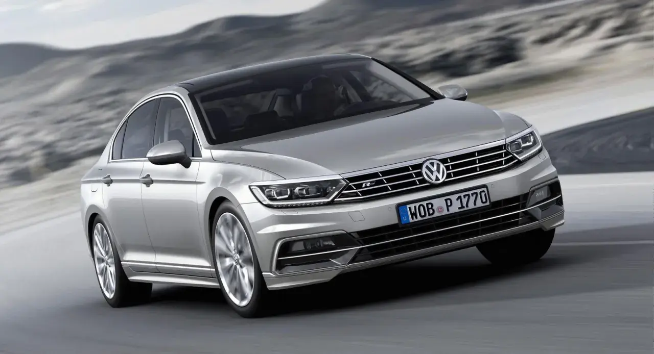Silver Passat GTR glider fram på en väg med berg i bakgrunden.
