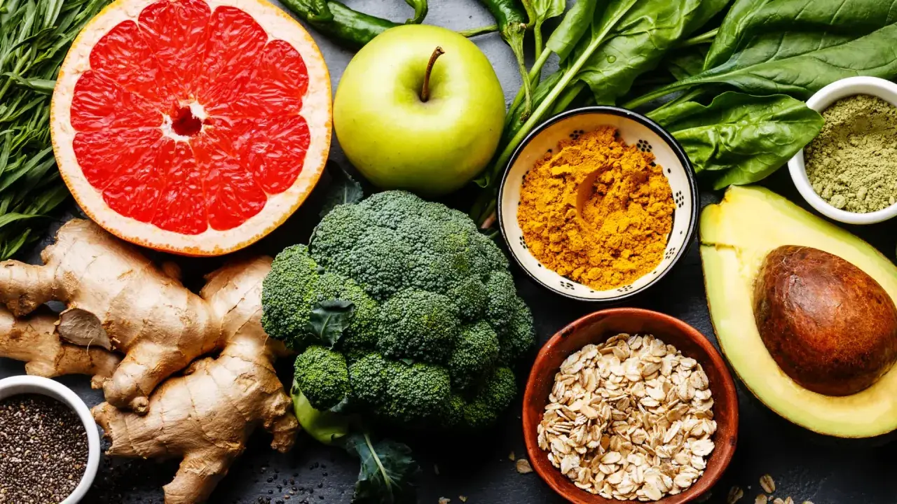 Bunte Auswahl an Lebensmitteln wie Grapefruit, Brokkoli, Avocado, Ingwer und Gewürzen, die wichtige Mineralstoffe liefern.