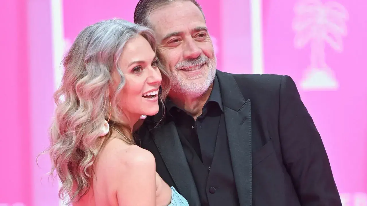 Jeffrey Dean Morgan, znany z filmów, seriali i programów, uśmiecha się do swojej żony na różowym tle.
