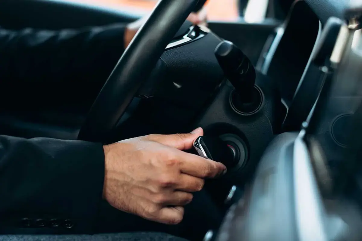Mano insertando la llave para la puesta en marcha del coche.