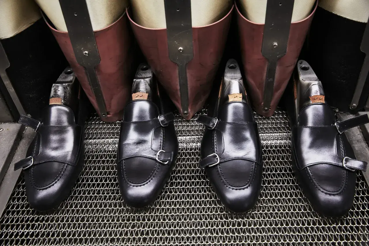 Scarpe marchigiane famose, mocassini neri con doppia fibbia, pronti per la lucidatura.