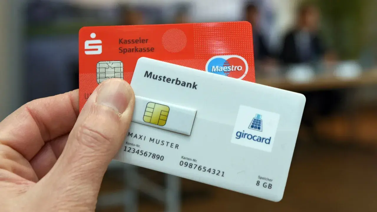 Eine rote Sparkassen-EC-Karte und eine weiße Girocard mit Maestro-Logo werden gezeigt.